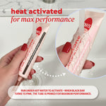 Two hands holding an Onyx Professional hand cream tube with text reading ‘heat activated for max performance,’ shown on a soft pink background.
