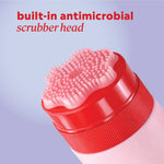 Close‑up of the pink antimicrobial scrubber head attached to the red cap of the Pedi Please foot mask tube, with text reading ‘built‑in antimicrobial scrubber head.’